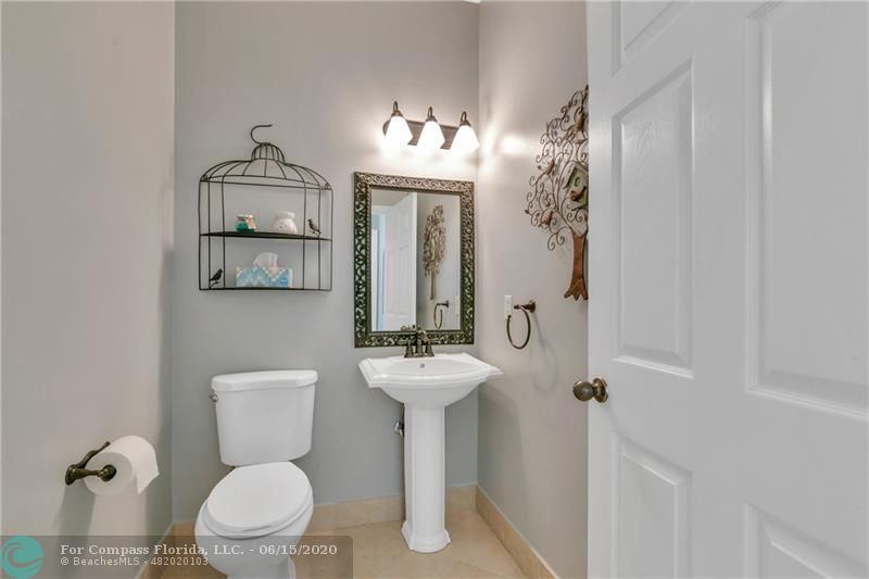7680 Belmonte Boulevard Margate, FL 33063 - Photo 25 of 30 a bathroom with a toilet sink and mirror
