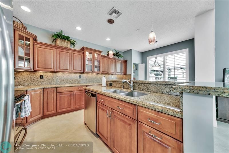 7680 Belmonte Boulevard Margate, FL 33063 - Photo 7 of 30 a kitchen with kitchen island granite countertop a sink window and cabinets