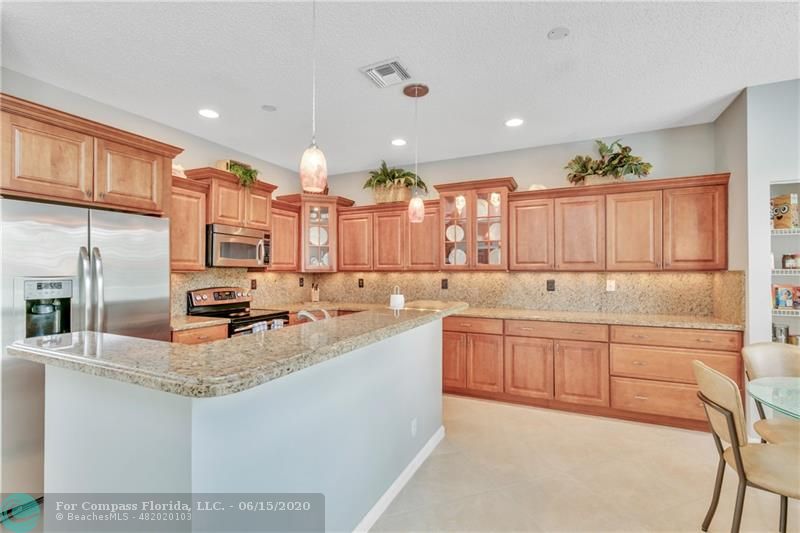 7680 Belmonte Boulevard Margate, FL 33063 - Photo 8 of 30 a large kitchen with stainless steel appliances kitchen island granite countertop a sink and cabinets