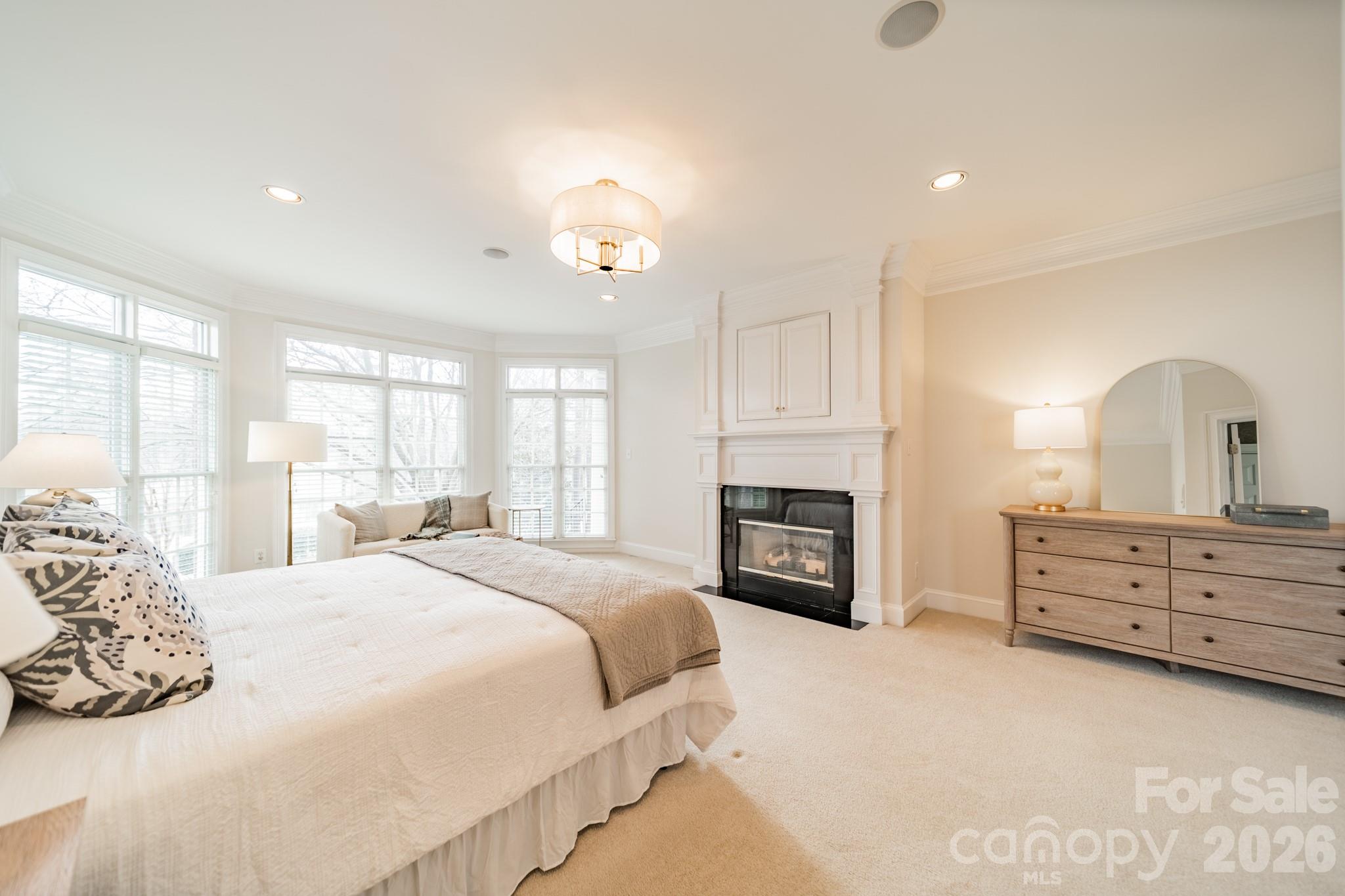 18908 Riverwind Lane Davidson, NC 28036 - Photo 18 of 35 a bedroom with a bed dresser and a fireplace