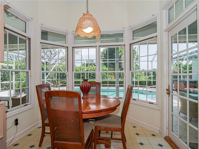 a dining room with furniture a chandelier and wooden floor
