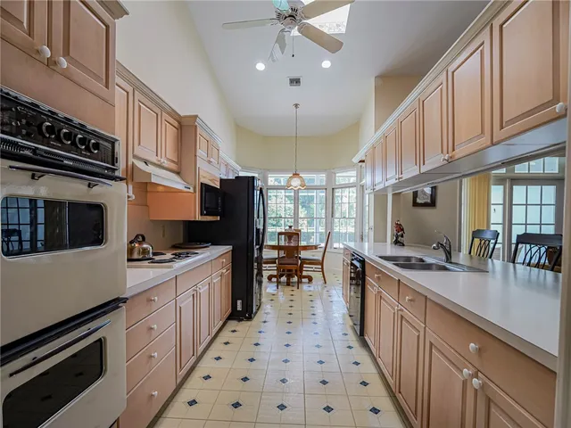 a kitchen with stainless steel appliances a sink a stove and a wooden floors