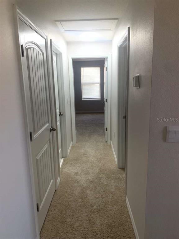 13251 Pontoon Road Winter Garden, FL 34787 - Photo 16 of 24 a view of a hallway with wooden floor and a bathroom