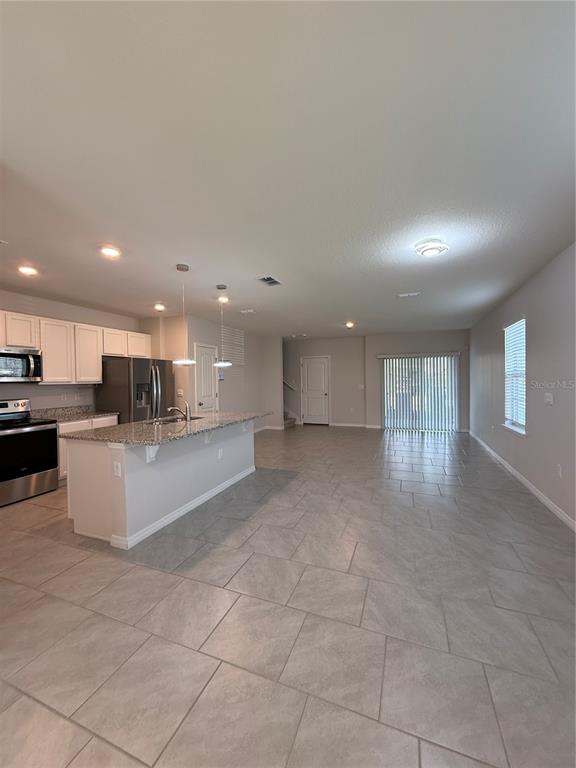 13251 Pontoon Road Winter Garden, FL 34787 - Photo 2 of 24 a view of kitchen with kitchen island granite countertop a stove a sink a refrigerator and a cabinets