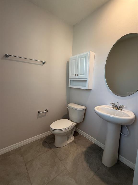 13251 Pontoon Road Winter Garden, FL 34787 - Photo 3 of 24 a bathroom with a toilet sink and mirror