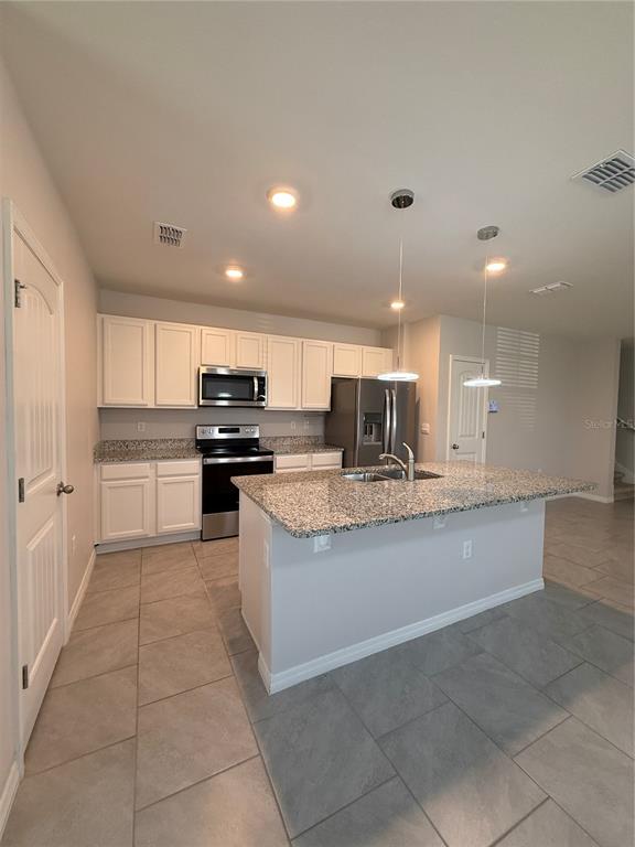 13251 Pontoon Road Winter Garden, FL 34787 - Photo 5 of 24 a kitchen with stainless steel appliances granite countertop a sink and cabinets