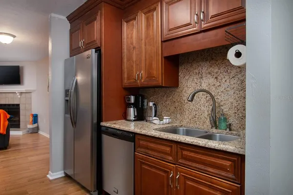 a kitchen with stainless steel appliances granite countertop a refrigerator and a sink