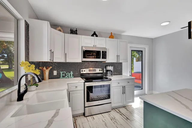 a kitchen with a sink a stove and cabinets