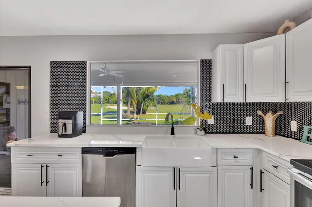 a kitchen with a sink a counter top space cabinets and appliances