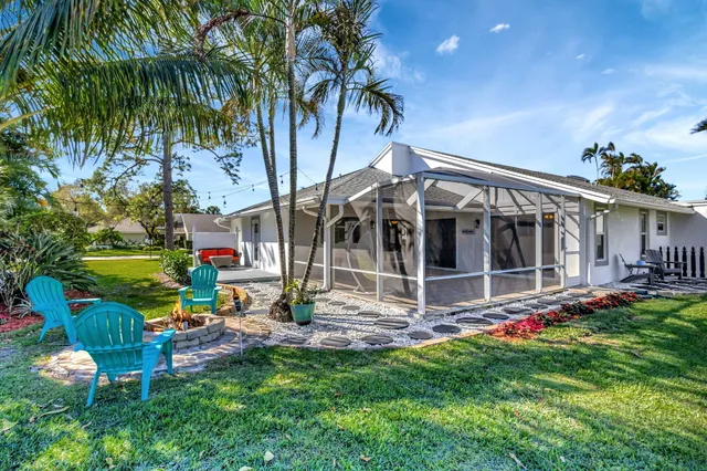 an aerial view of residential houses with outdoor space and trees