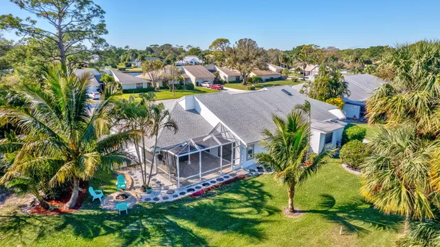 a front view of a house with garden and tree