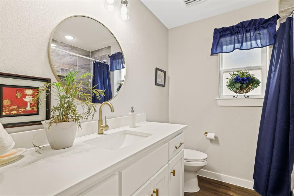114 West Morton Street Denison, TX 75021 - Photo 16 of 22 a bathroom with a sink a toilet and a mirror