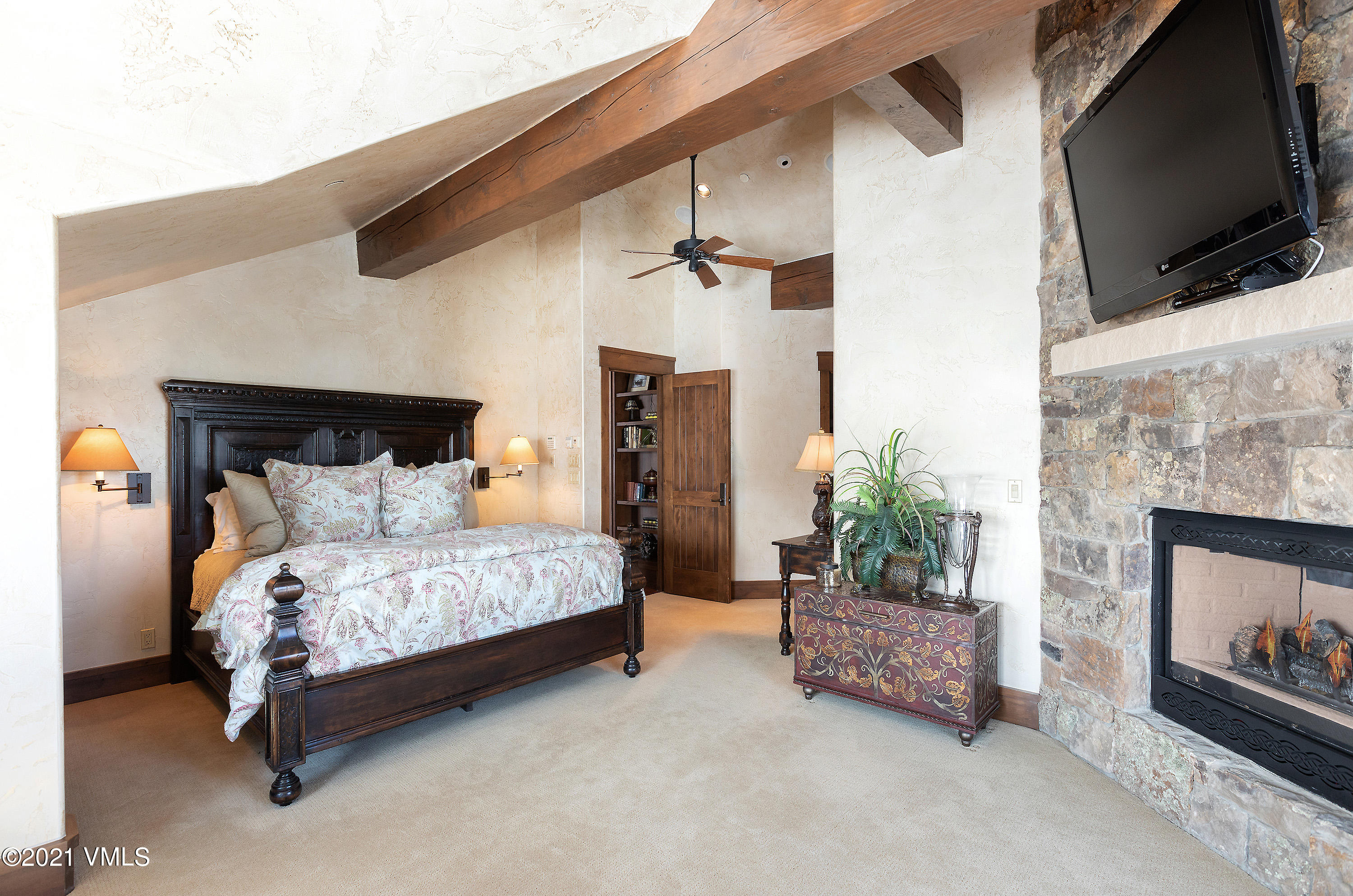 1092 Summit Trail Edwards, CO 81632 - Photo 23 of 48 a bedroom with a bed a flat screen tv and a fireplace