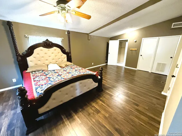 a bedroom with a bed and hardwood floor