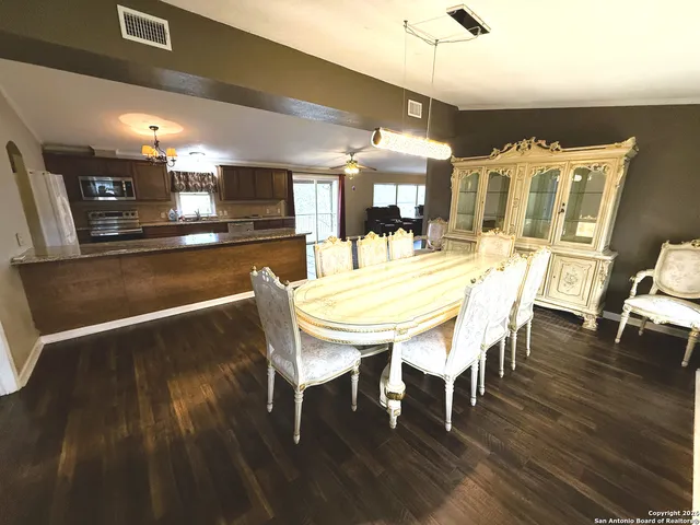 a dining room with furniture a chandelier and wooden floor
