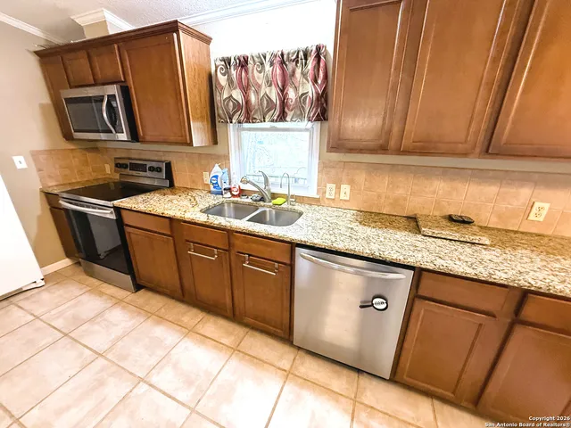 a kitchen with stainless steel appliances granite countertop a sink stove and cabinets
