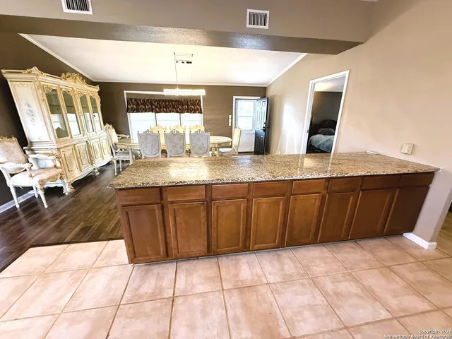 a en suite bathroom with a granite countertop sink and a mirror
