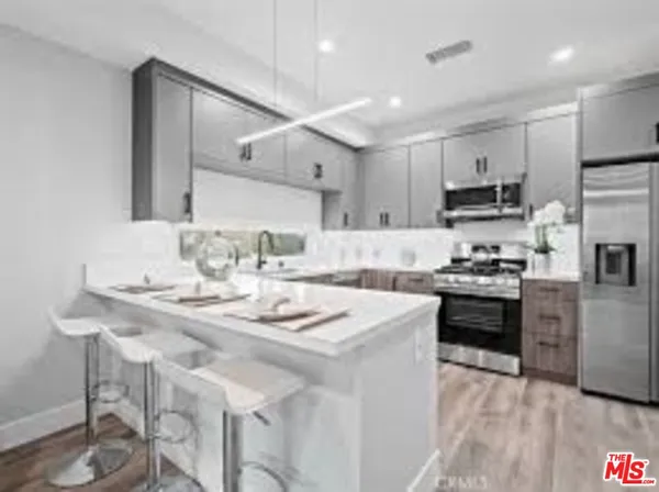 a kitchen with kitchen island granite countertop a sink cabinets and stainless steel appliances