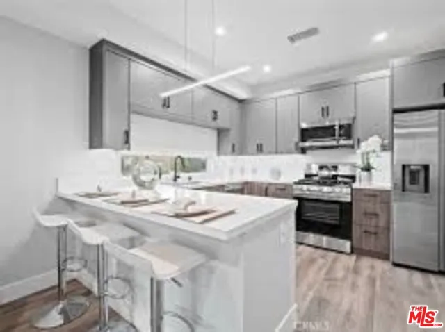 a kitchen with kitchen island granite countertop a sink cabinets and stainless steel appliances