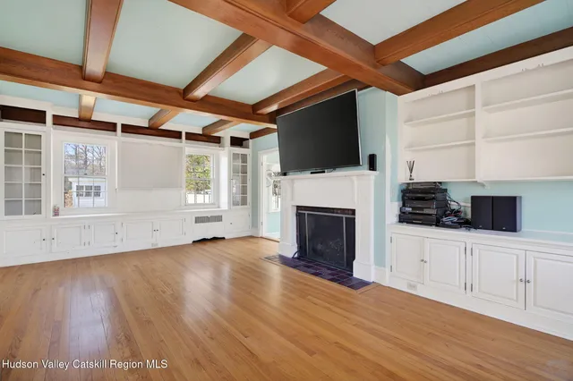 a view of empty room with wooden floor and fireplace