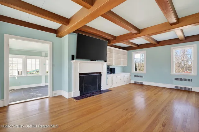 a view of an empty room with a fireplace and a window