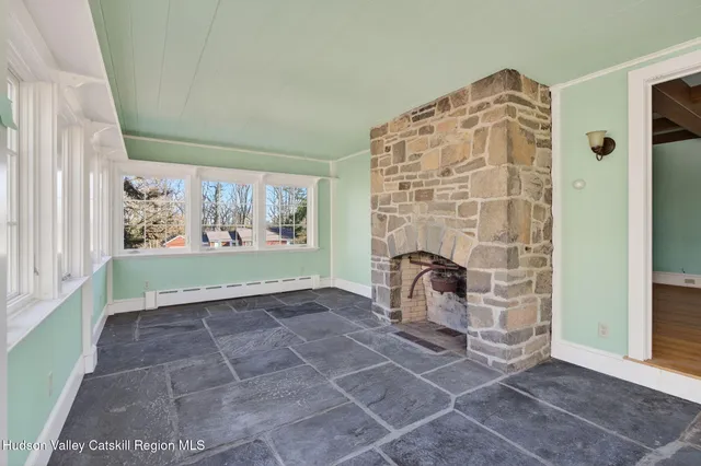 a view of an empty room with window and front door