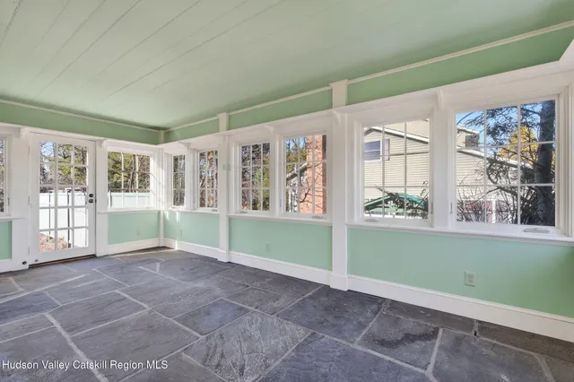 a view of a hallway with wooden floor and a bathroom