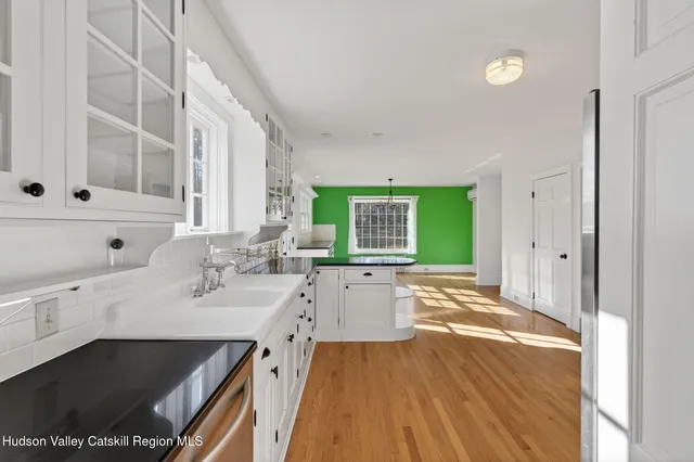 a kitchen with granite countertop a stove and white cabinets