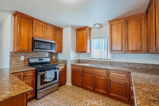 a kitchen with stainless steel appliances granite countertop cabinets and window