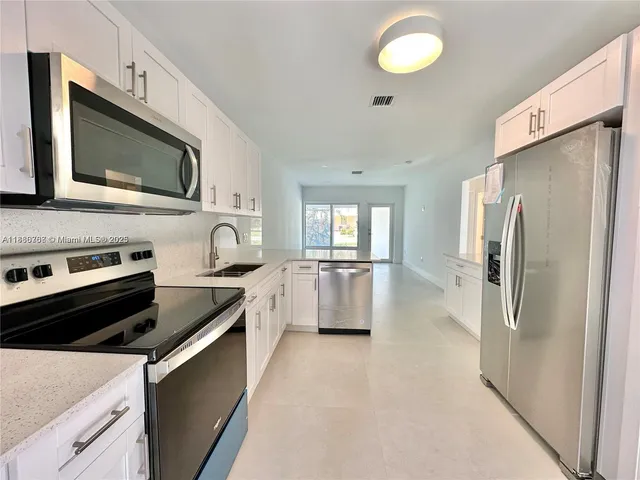 a kitchen with stainless steel appliances a refrigerator sink and stove