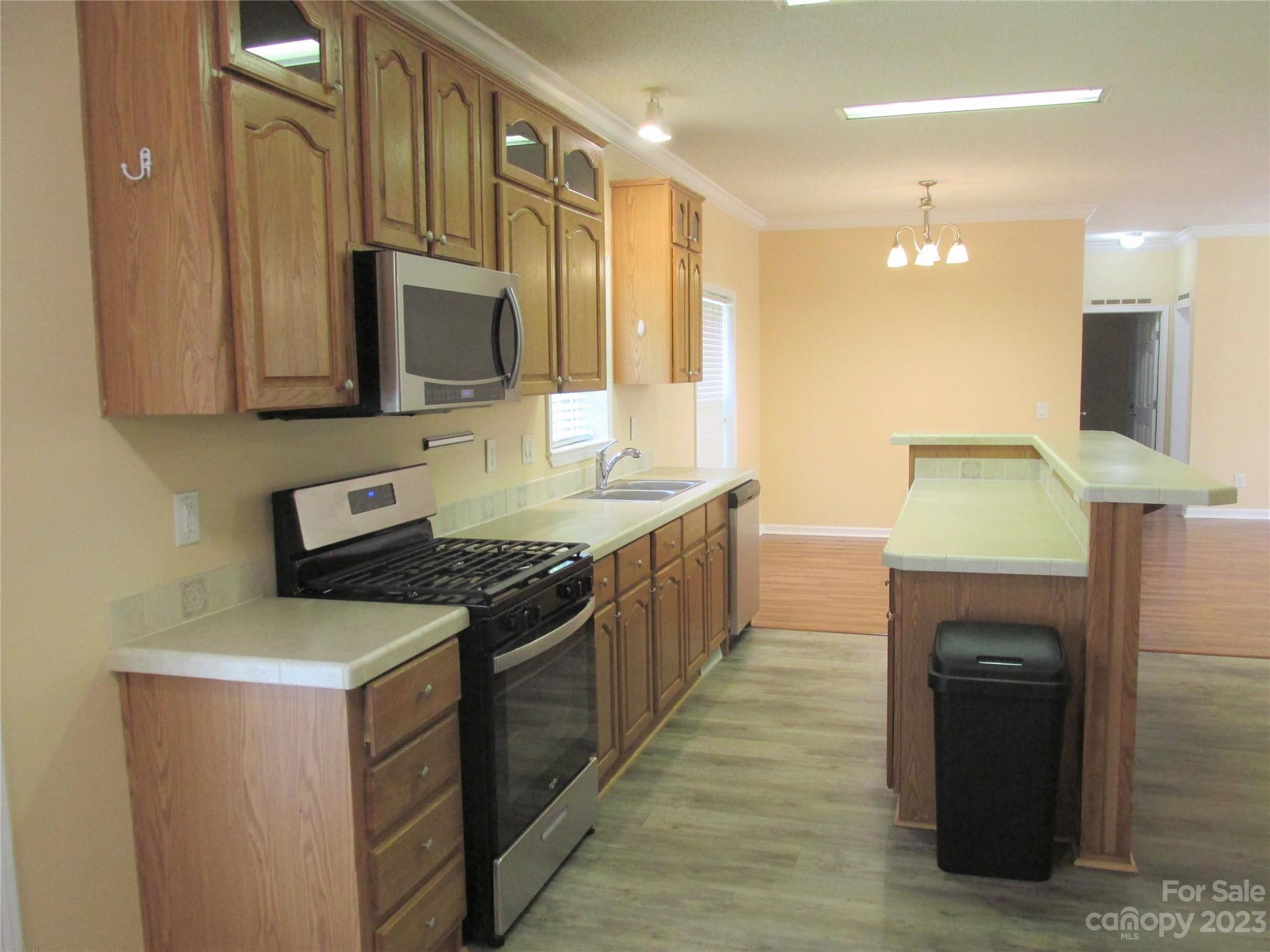 407 Monteith Gap Road Cullowhee, NC 28723 - Photo 9 of 27 a kitchen with stainless steel appliances granite countertop a stove a sink and a microwave
