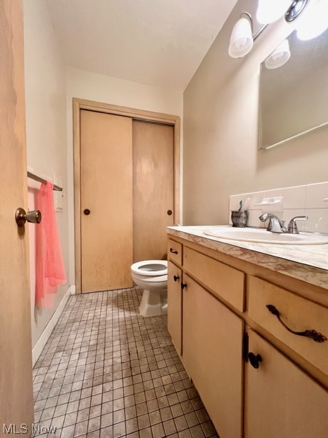 2480 Noble Road Cleveland, OH 44121 - Photo 13 of 31 Bathroom featuring backsplash, large vanity, toilet, and tile flooring