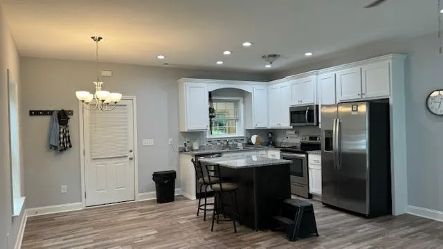 a kitchen with a sink cabinets and wooden floor