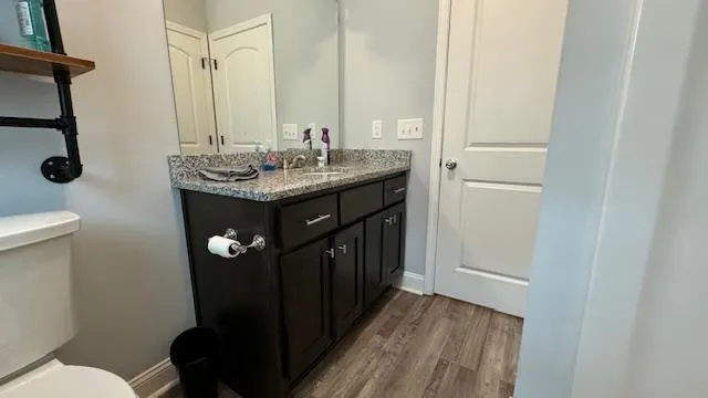 a view of a house with a yard plants and large tree