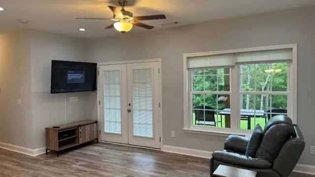 a living room with furniture a flat screen tv and a window