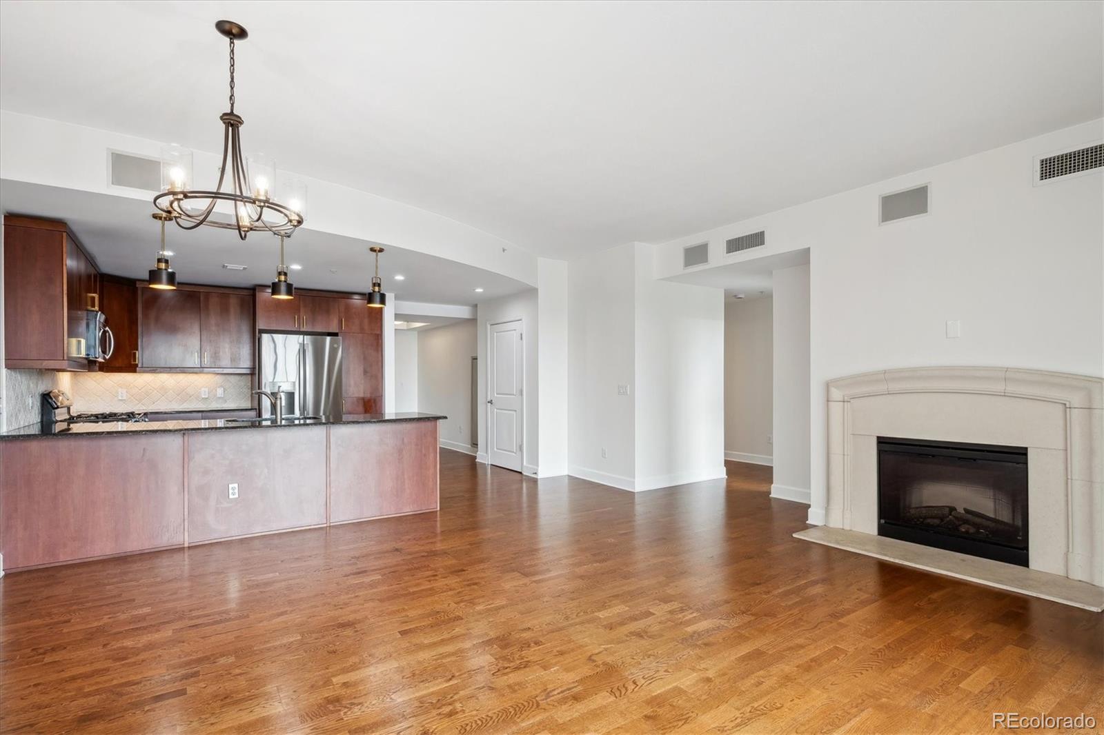 2990 East 17th Avenue, Unit 803 Denver, CO 80206 - Photo 1 of 29 a view of a kitchen with a sink wooden floor and a chandelier