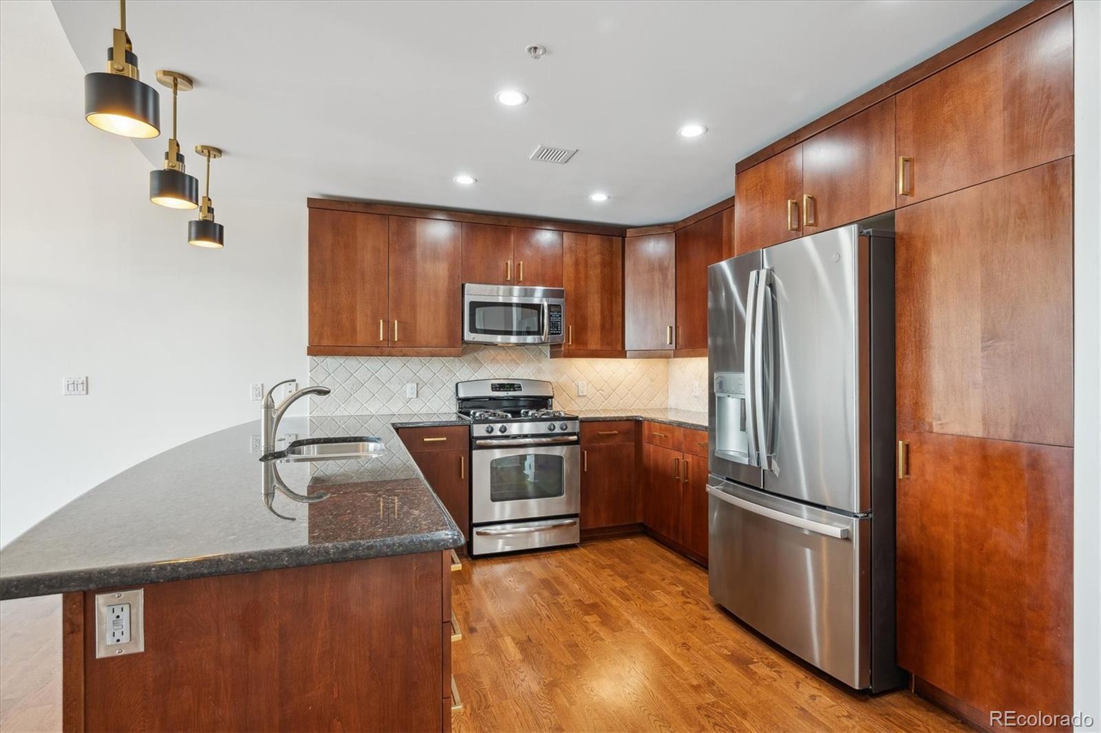 2990 East 17th Avenue, Unit 803 Denver, CO 80206 - Photo 3 of 29 a kitchen with granite countertop a refrigerator and a sink