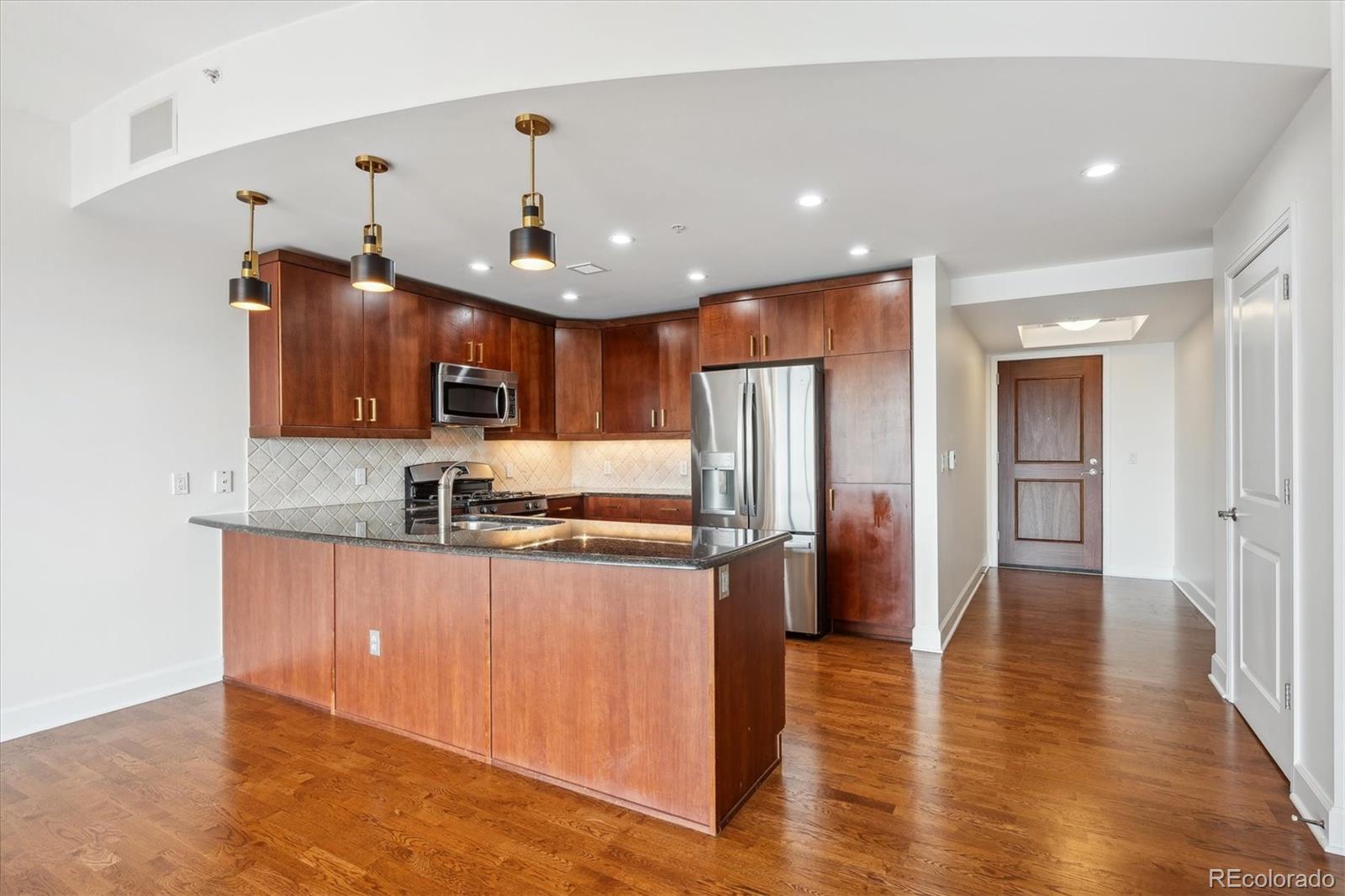 2990 East 17th Avenue, Unit 803 Denver, CO 80206 - Photo 4 of 29 a kitchen with stainless steel appliances granite countertop a refrigerator a sink dishwasher a stove and white countertops with wooden floor