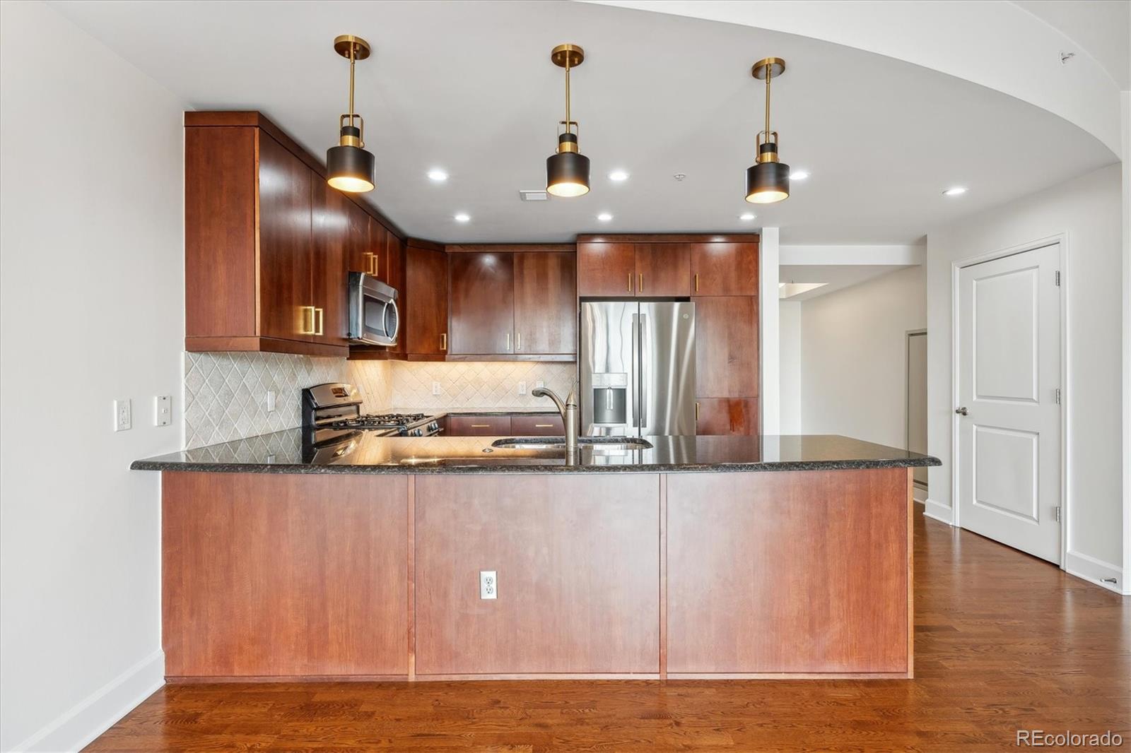 2990 East 17th Avenue, Unit 803 Denver, CO 80206 - Photo 5 of 29 a large kitchen with stainless steel appliances granite countertop a granite counter tops and a wooden floors
