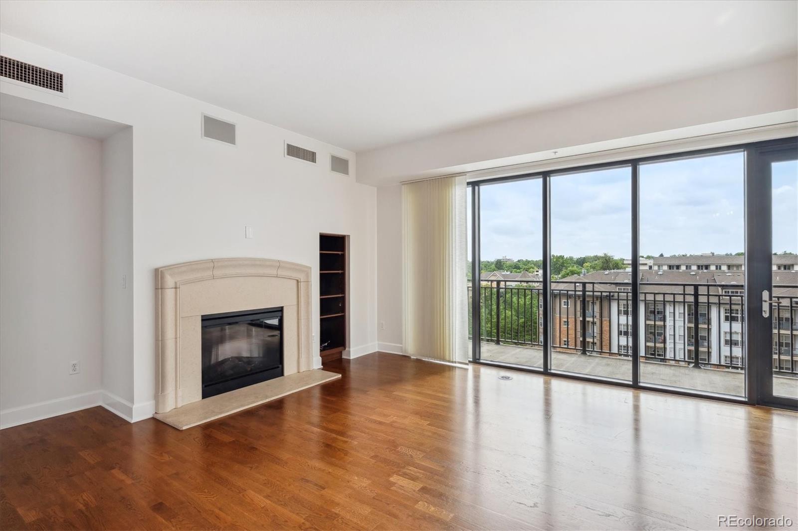 2990 East 17th Avenue, Unit 803 Denver, CO 80206 - Photo 7 of 29 a view of an empty room with wooden floor fireplace and a window