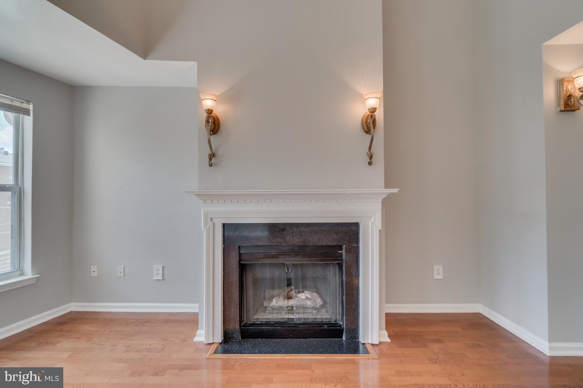 12000 Market Street, Unit 419 Reston, VA 20190 - Photo 14 of 38 Working gas fireplace with elegant light fixtures