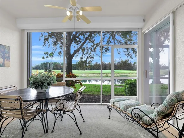 a dining room with furniture water view and a floor to ceiling window