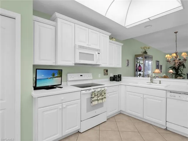 a kitchen with white cabinets and sink