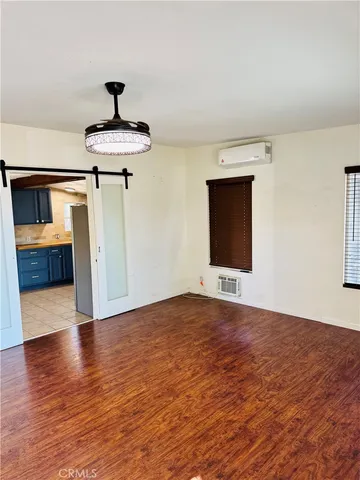 a view of hallway with wooden floor and chandelier