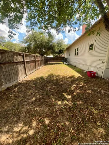 a view of backyard with wooden fence