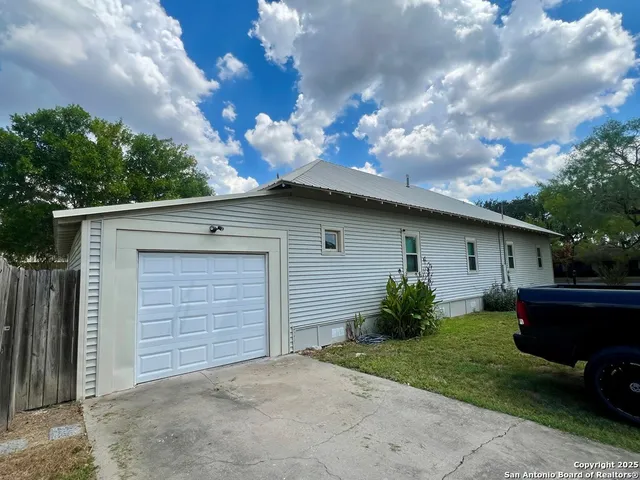 a backyard of a house with plants and garage