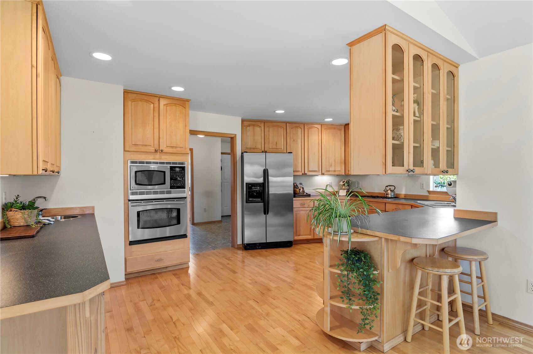 18927 Fales Road Snohomish, WA 98296 - Photo 5 of 18 a kitchen with granite countertop a refrigerator cabinets and wooden floor