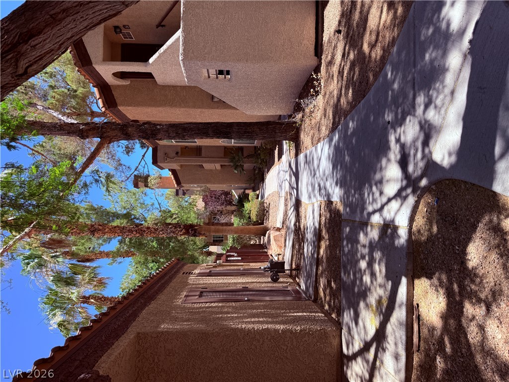 9325 West Desert Inn Road, Unit 260 Las Vegas, NV 89117 - Photo 39 of 42 A winding walkway through the desert community offers tranquil strolls amidst established trees.