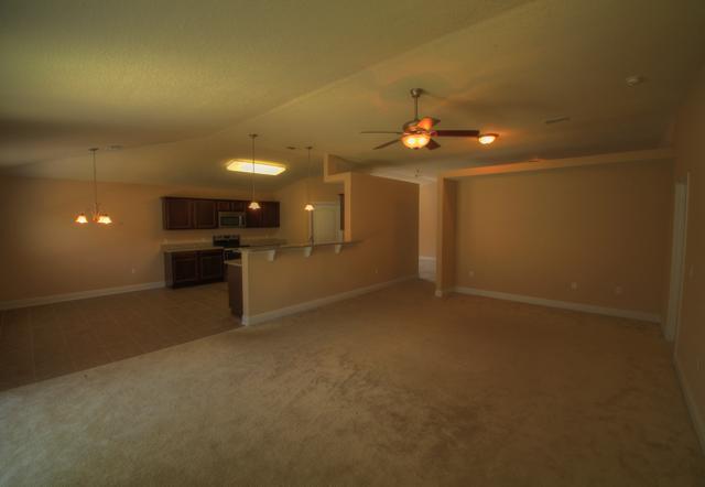 4547 Hermosa Road Crestview, FL 32539 - Photo 14 of 26 an empty room with a kitchen and chandelier fan