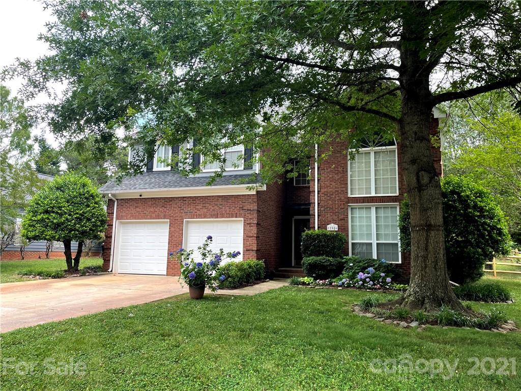 12506 Moores Mill Road Huntersville, NC 28078 - Photo 1 of 1 a front view of a house with a garden and a tree